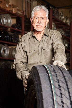 Car mechanic with workshop experience Stock with tire for tire changingの写真素材