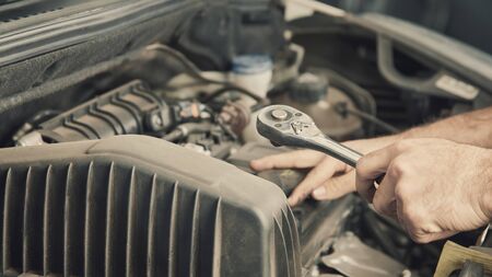 Mechantroniker repairs engine of car in the workshop during an inspectionの写真素材