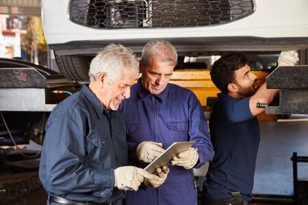 Mechatronics team makes car inspection with tablet computer and diagnostic appの写真素材