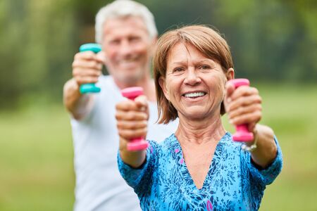 Senior couple exercising with dumbbells in a rehabilitation course for toning