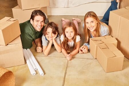 Happy family with two kids in new condo between cartons