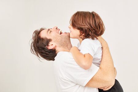 Happy father hugs his son laughing on greeting or goodbyeの写真素材