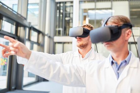 Two researchers train with VR glasses in simulation for medical applications