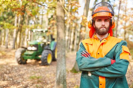Self-confident forest worker or forestry worker in protective clothing during forest workの写真素材