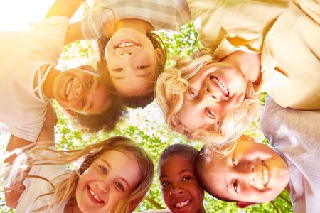 Integration by happy multicultural kids in circle in summer in natureの写真素材