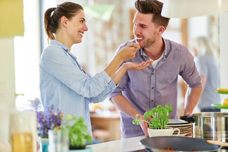 Young couple cooking and seasoning together in the kitchen