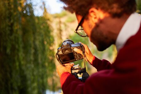 Photographer as a nature photographer or wildlife photographer clips camera on the tripodの写真素材