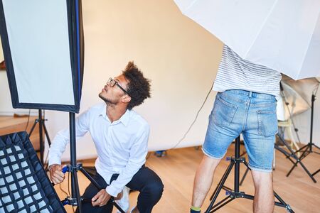 Photo assistants team in the photo studio preparing a photo shoot
