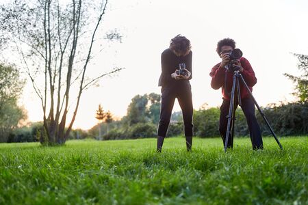 Photographer team on a meadow with camera and tripod as nature photographerの写真素材