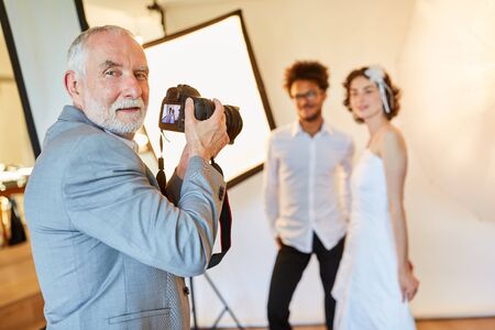 Experienced wedding photographer takes pictures of the newlyweds on the wedding dayの写真素材