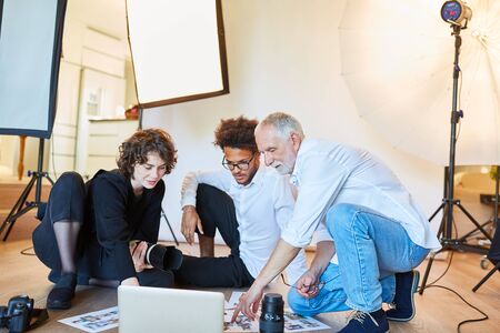 Photographer Team and Art Director discuss a photo shoot in the studioの写真素材