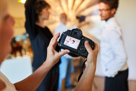 Photographer inspects portrait photo on the display of the digital cameraの写真素材