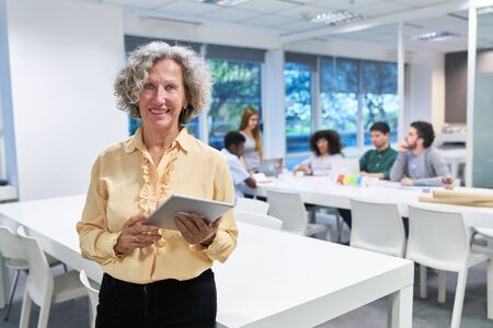 Senior woman as a lecturer with tablet computer before a business meeting or workshopの写真素材