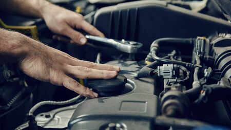 Hand of mechatronics engineer at the engine of the car during an inspectionの写真素材