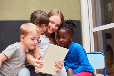 Teacher or kids using tablet computer have fun with social mediaの写真素材