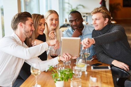 Young start-up people are looking at a tablet computer in the restaurant