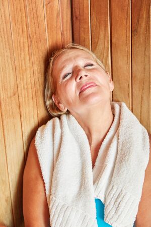 Senior woman enjoys the healthy heat in the sauna at the Wellness Hotelの写真素材