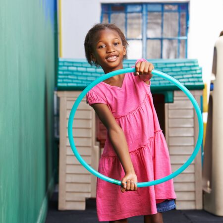 African child is playing with a tire in kindergartenの写真素材