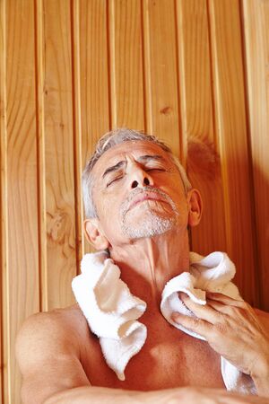 Senior man relaxes in a sauna on vacationの写真素材