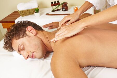 Attractive man gets a relaxing massage at the day spaの写真素材