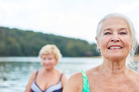 Happy vital senior woman in nature in a wellness class or on vacationの写真素材