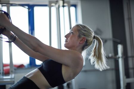 Young woman in sling training as a healthy back training at the train stationの写真素材