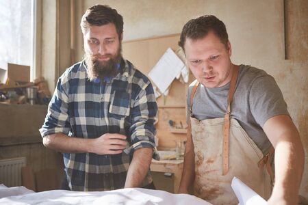 Carpenter team looks at an architectural drawing for a carpentry job