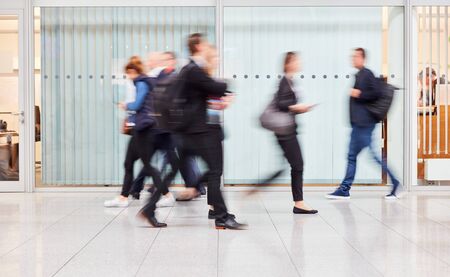 Anonymous blurred group of business people go on gear in the officeの写真素材