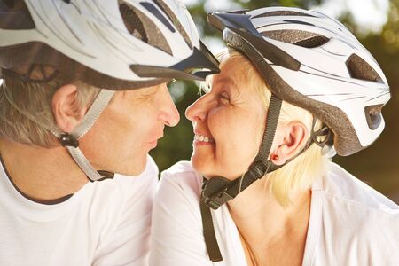 Woman and man with bicycle helmet kiss on a bike tourの写真素材