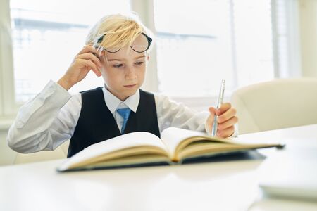 Child disguised as a businessman or controller or accountant at auditの写真素材