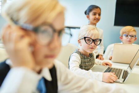 Child as a young businessman is talking on the mobile phone in the business meetingの写真素材