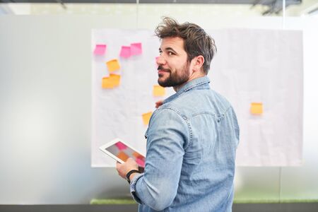 Young business man has an idea while creative brainstorming with sticky notes