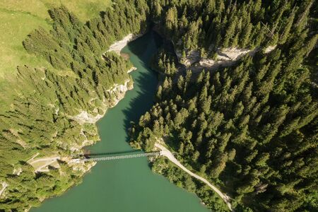 Aerial view of bridge for pedestrians over Lac de Roselend lake in Savoie, France