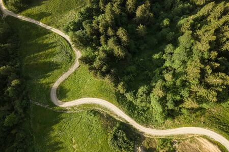 Aerial view of winding road from above through forest in the French Alpsの写真素材