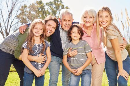 Happy extended family with children and grandparents in the summer in the garden