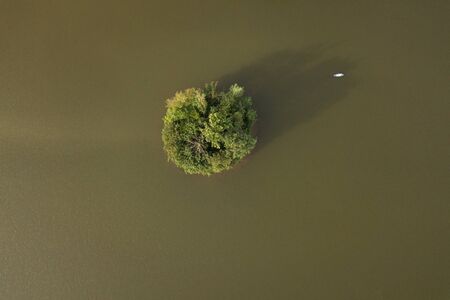 Aerial view of small island on lake with boat in summerの写真素材