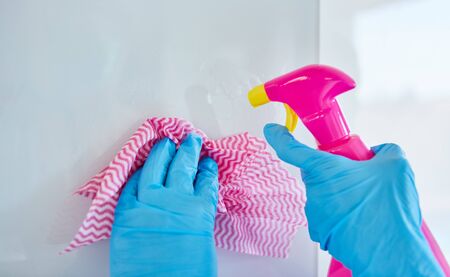 Cleaning lady with disposable gloves during cleaning and disinfection in a clinic during a...