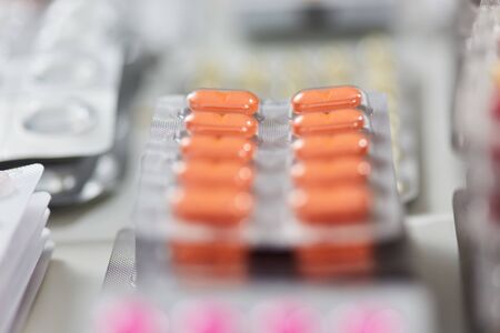 Stacked medicines drugs as colorful tablets in blister packaging