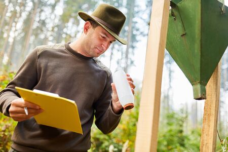FÃ¶rster controls measuring beakers of the bark beetle trap for pest control
