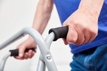 Hands of senior while walking on the walker