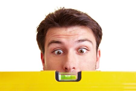 Craftsman looks in amazement at a yellow spirit levelの写真素材