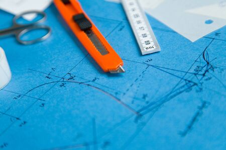 Cutter knife lies on a blue patternの写真素材