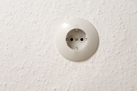 A round wall socket with white wallpaperの写真素材