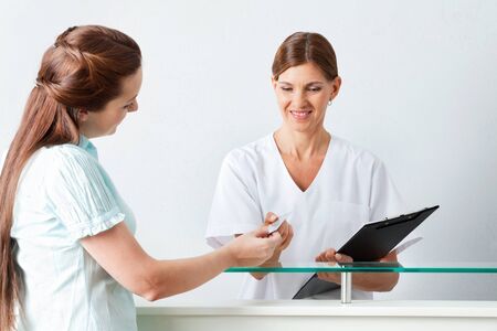 Patient gives her chip card to a doctorの写真素材