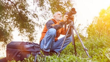 Photographer with camera and tripod in nature in landscape photography