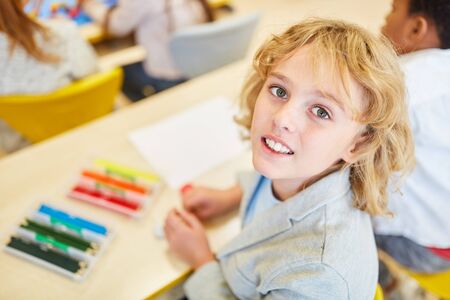 Blond boy as a school freshman while learning in preschool or elementary school