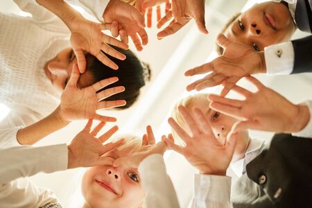 Children stand in a circle and show their hands for friendship and integrationの写真素材
