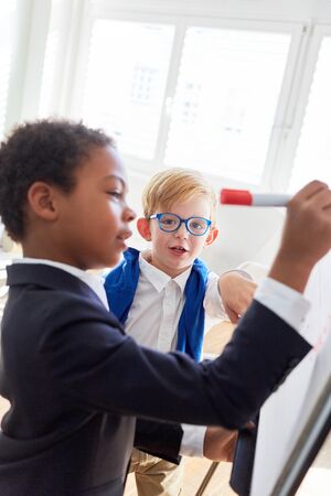 African child as a designer or businessman on whiteboard with felt-tip penの写真素材