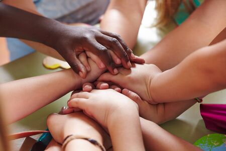 Many children in kindergarten stack hands as a groupの写真素材
