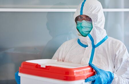 Medic in protective clothing during transportation of organ donation for surgery in clinic